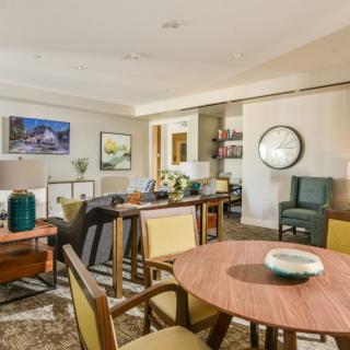 A cozy living room with a dining table set, comfortable chairs, and elegant decor.