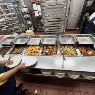 A cafeteria buffet line with various dishes in trays ready to be served.