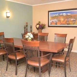 A well-decorated dining room with a wooden table and chairs, featuring artwork on the wall.