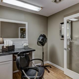 A modern hair salon interior with a styling chair, mirror, and hair dryer.