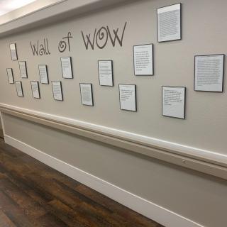 A 'Wall of Wow' featuring framed documents and letters in a hallway.