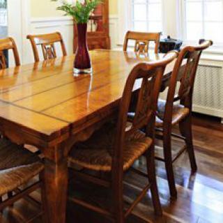 A beautifully arranged wooden dining table set with chairs in a bright room.