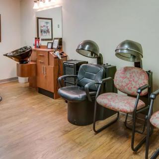 A salon interior with chairs and hair drying equipment.