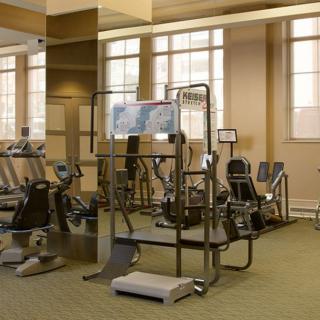 A spacious gym with various exercise equipment including treadmills and ellipticals.