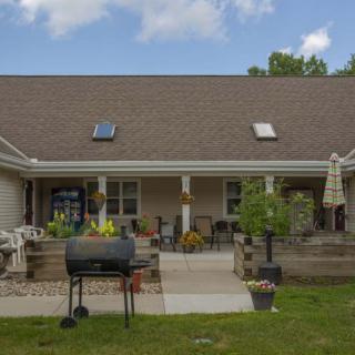 A backyard patio area featuring outdoor furniture, a barbecue grill, and skylights on the roof.