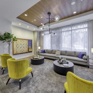 A chic living room with modern decor, featuring yellow chairs and a gray sofa.