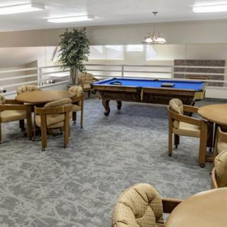 A recreational game room featuring a pool table and several tables with chairs.