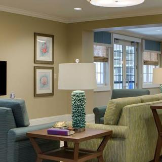 A cozy living room with comfortable seating, stylish lamps, and framed artwork on the walls.