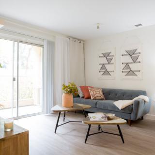 A modern living room with a stylish sofa and coffee table, complemented by geometric artwork and a cozy atmosphere.