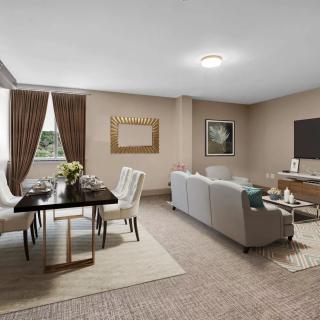 A modern living room with an adjoining dining area, featuring a comfortable sofa, dining table with chairs, and tasteful decor.