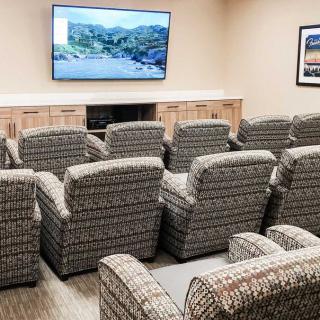 A cozy home theater setup with multiple recliners and a large screen television.