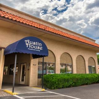 Exterior view of a restaurant with an entrance awning under a cloudy sky.