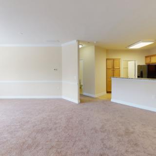 Spacious open-plan living room with a view of the kitchen area.