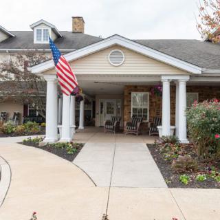 The entrance of a building with white columns and an American flag.