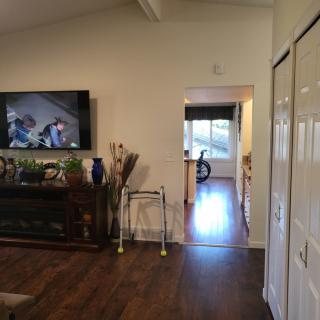 A cozy living room with a television and hallway leading to another room.