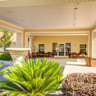 A welcoming porch with lush greenery and comfortable outdoor seating.