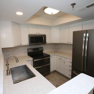 A modern kitchen featuring stainless steel appliances and white cabinets.