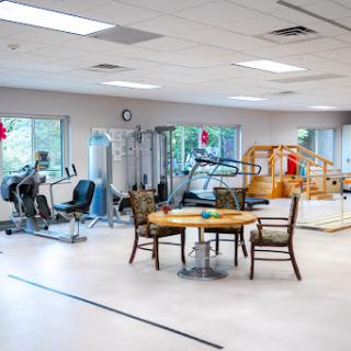 A well-equipped gym area featuring exercise machines and a casual seating arrangement.