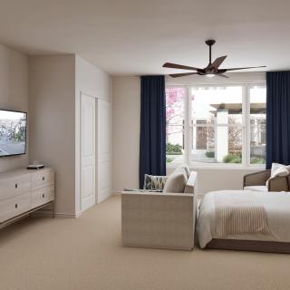 A modern bedroom featuring a bed, television, and ceiling fan with large windows and curtains.