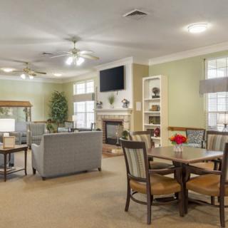 A cozy living room with a dining area, featuring a sofa, television, and fireplace.