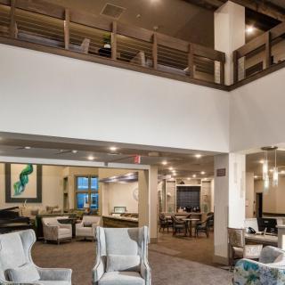 A modern living room with a loft, featuring comfortable seating and elegant decor.