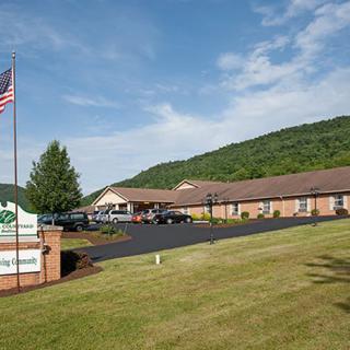 A roadside motel with a parking lot and an American flag, set against a backdrop of rolling hills.
