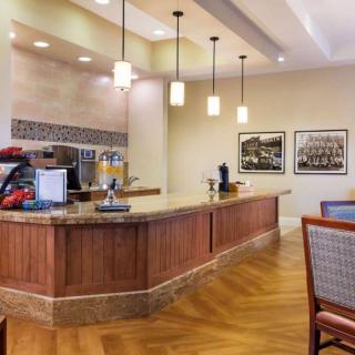 A cozy coffee shop interior featuring a wooden counter with pendant lighting and seating.