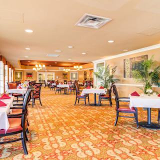 A spacious and elegantly decorated restaurant dining area with neatly arranged tables and chairs.