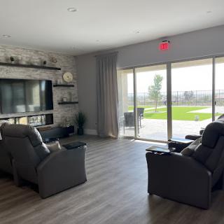 A modern living room featuring comfortable recliners and a beautiful outdoor view.