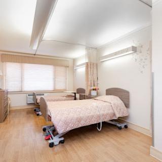 A clean and well-lit patient room in a hospital, equipped with two beds.