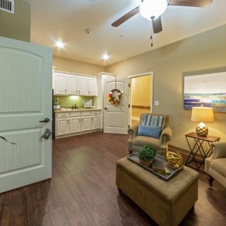A cozy living area with an open kitchen, featuring comfortable seating and warm lighting.