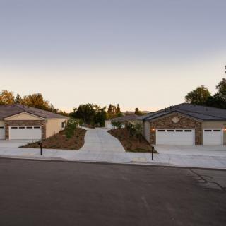 Two suburban houses with driveways at sunset.