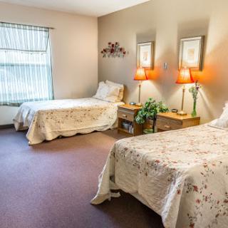 A cozy bedroom featuring two beds, warm lighting, and inviting decor.