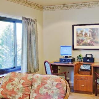 A cozy office space with a desk, computer, and a comfortable sofa.