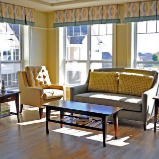 A sunny living room with a sofa, armchair, and coffee table.