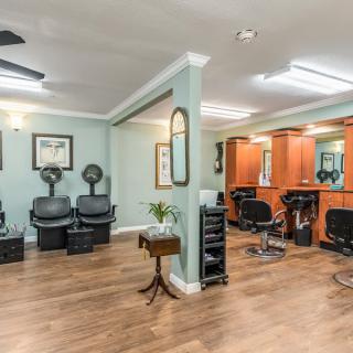 A modern hair salon interior with styling stations and comfortable seating.