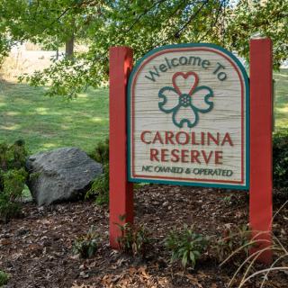 A welcoming sign for Carolina Reserve surrounded by greenery.