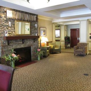 A cozy lobby with a stone fireplace, comfortable seating, and soft lighting.