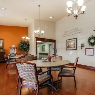 A cozy dining area with a round table, chairs, and elegant chandeliers.