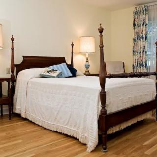 A cozy bedroom with a four-poster bed and soft lighting.