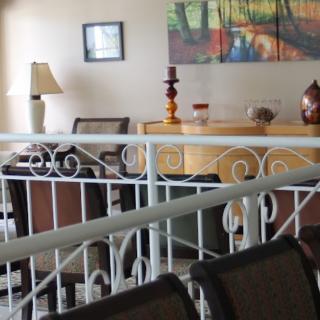 A cozy living room with a lamp, decorative items, and artwork on the wall.