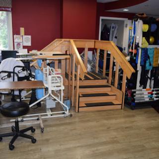 A well-equipped therapy room featuring a set of stairs for rehabilitation exercises.