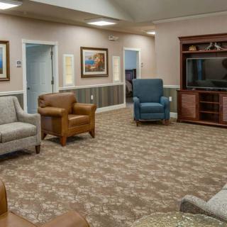 A cozy living room with various chairs, a TV stand, and decorative elements.
