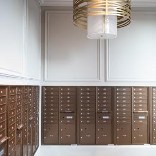 A modern interior with rows of mailboxes and a contemporary light fixture.