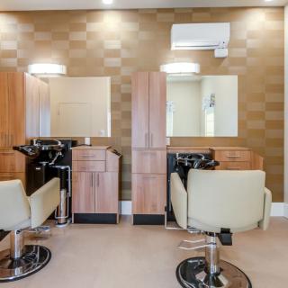 A modern salon interior with two haircut stations featuring mirrors and chairs.