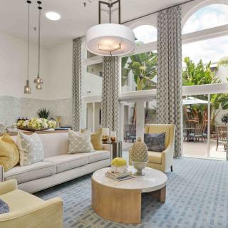 A spacious living room featuring modern decor with large windows allowing natural light to fill the space.