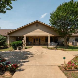 A single-story building with a landscaped front yard and driveway.