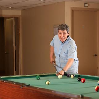 A person playing billiards on an indoor pool table.