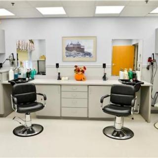 A clean and well-organized barbershop interior with two styling chairs and various hairdressing tools.