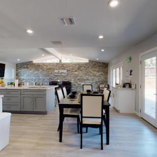 A modern open-concept kitchen and dining area with natural light and wooden floors.